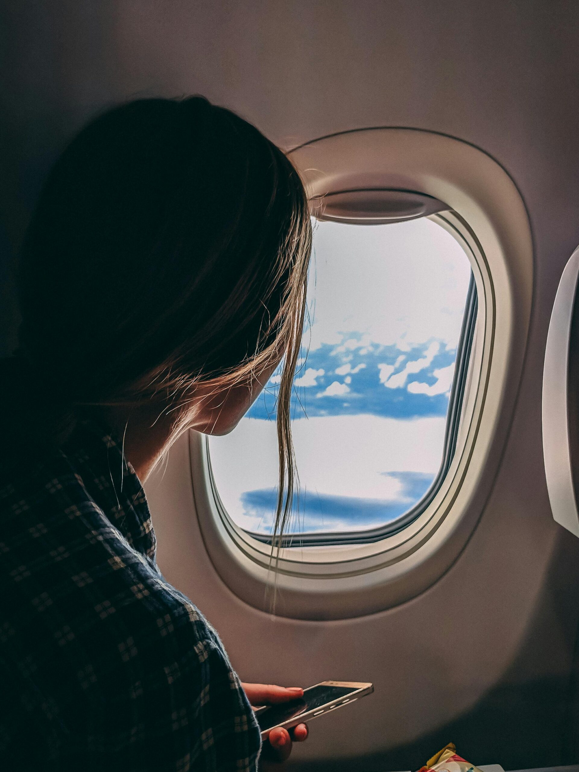 CARO O BARATO VIAJAR A MÉXICO MUJER MIRANDO A LA VENTANA REPRESENTANDO SI ES BARATO O CARO VIAJAR A MÉXICO